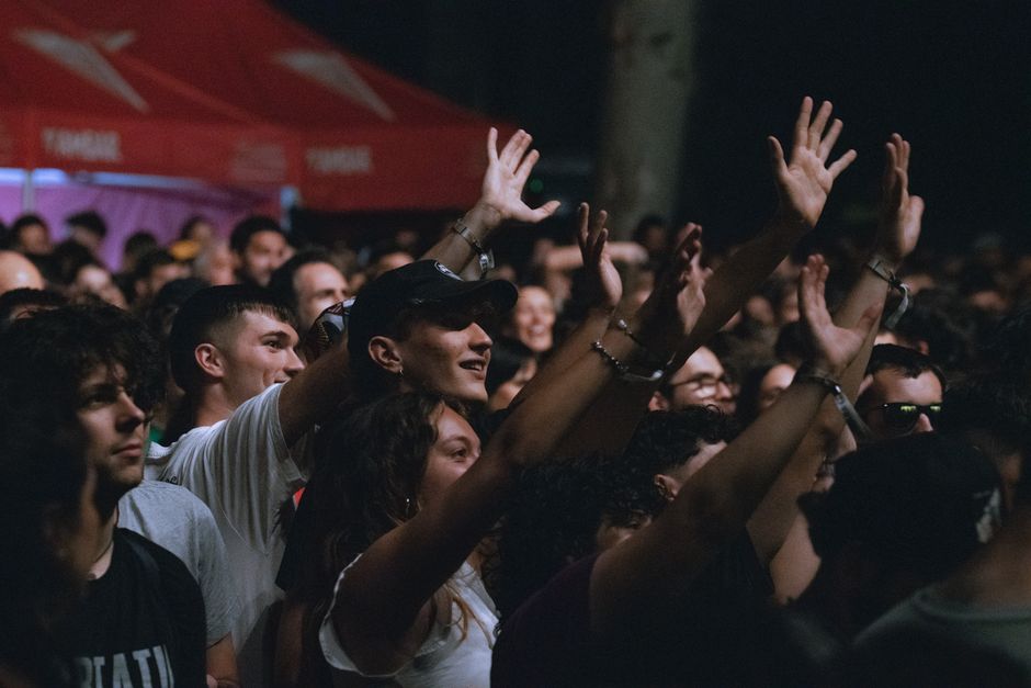 Turismo Sustentável — A lively crowd enjoying a vibrant outdoor music festival under night lights.