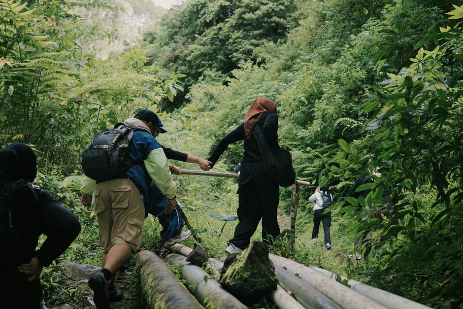 Turismo Sustentável — A group of hikers traverse a lush rainforest trail in Jawa Barat, Indonesia, enjoying an active