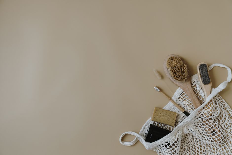 Turismo Sustentável — Collection of eco-friendly bath essentials, featuring a wooden brush and soap in a mesh bag. Ideal